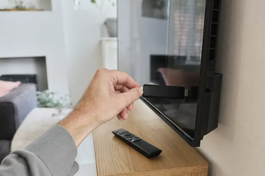 Plugging a streaming stick into a TV to install IPTV on Firestick